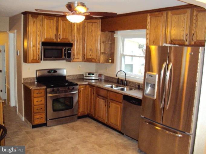 9006 Tammy Road Nottingham, MD 21236 - Photo 3 of 14 a kitchen with stainless steel appliances granite countertop a refrigerator a sink a stove a microwave and island