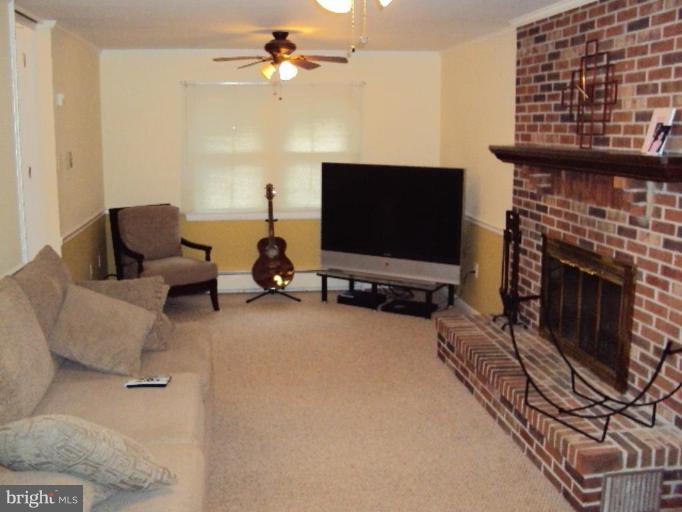 9006 Tammy Road Nottingham, MD 21236 - Photo 4 of 14 a living room with furniture a flat screen tv and a fireplace