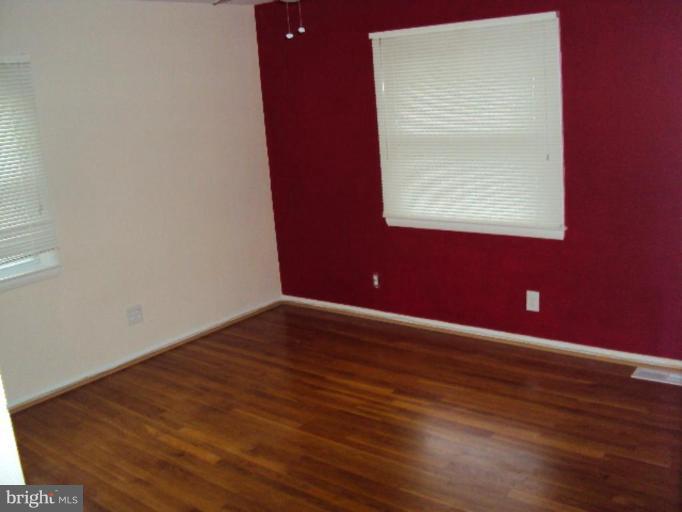 9006 Tammy Road Nottingham, MD 21236 - Photo 6 of 14 a view of an empty room with wooden floor and a window