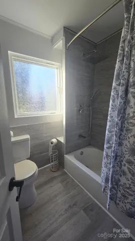 a bathroom with a toilet and a shower
