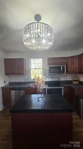 a kitchen with a stove and a chandelier