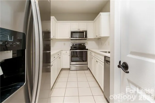 a kitchen with granite countertop a sink a stove and cabinets
