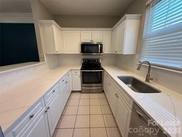 a kitchen with granite countertop a sink and a stove
