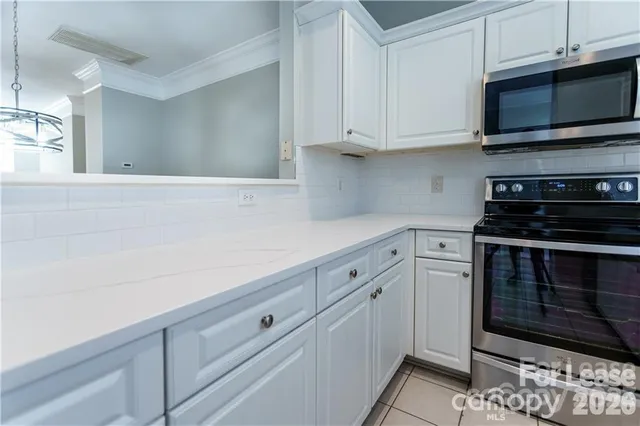 a view of an empty room with chandelier and window