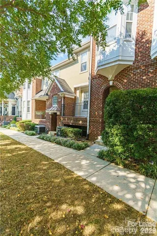 a view of a house next to a yard with plants and trees