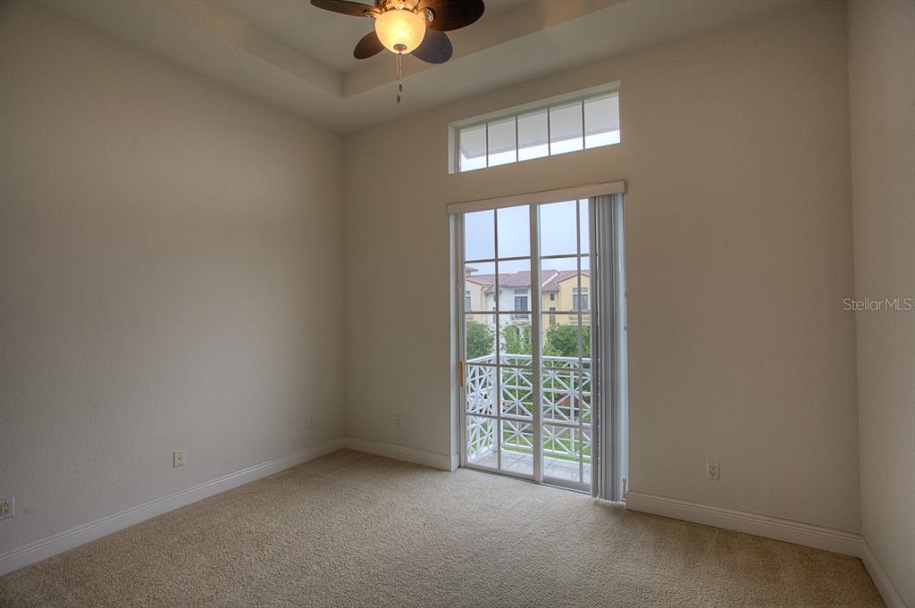 6021 Printery Street, Unit 106 Tampa, FL 33616 - Photo 15 of 23 an empty room with a chandelier fan and windows