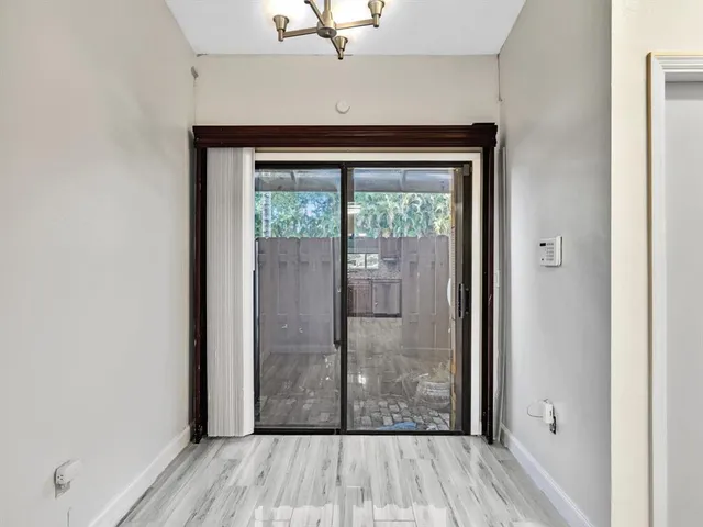 a view of a hallway with wooden floor and a bathroom