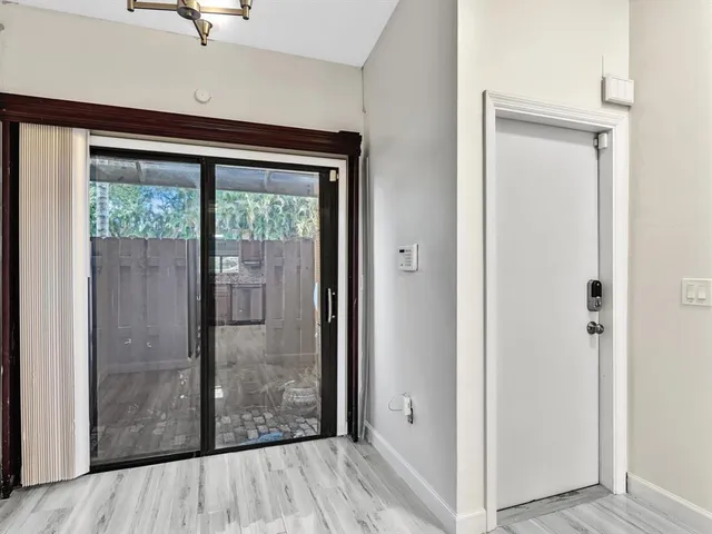 a view of a hallway with wooden floor and windows