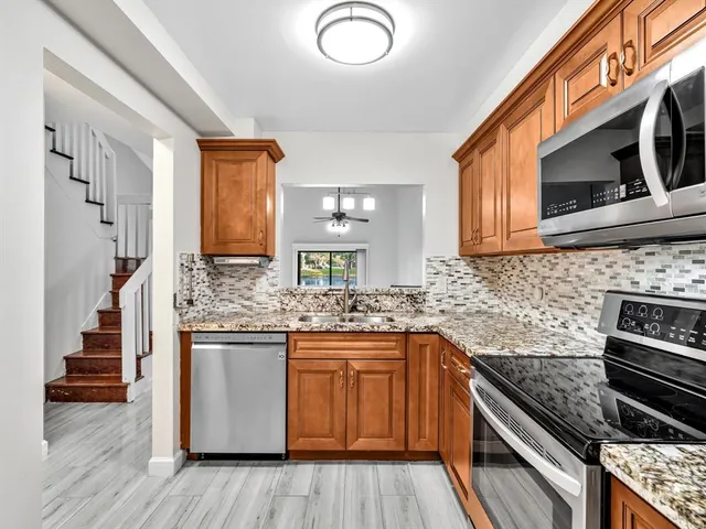 a kitchen with stainless steel appliances granite countertop a stove and a microwave