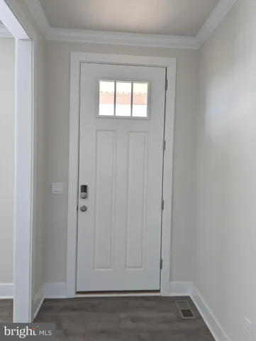 a view of an empty room with wooden floor and closet
