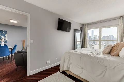 a bedroom with a bed tv and a window