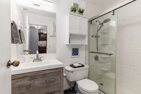 a bathroom with a sink vanity mirror and toilet