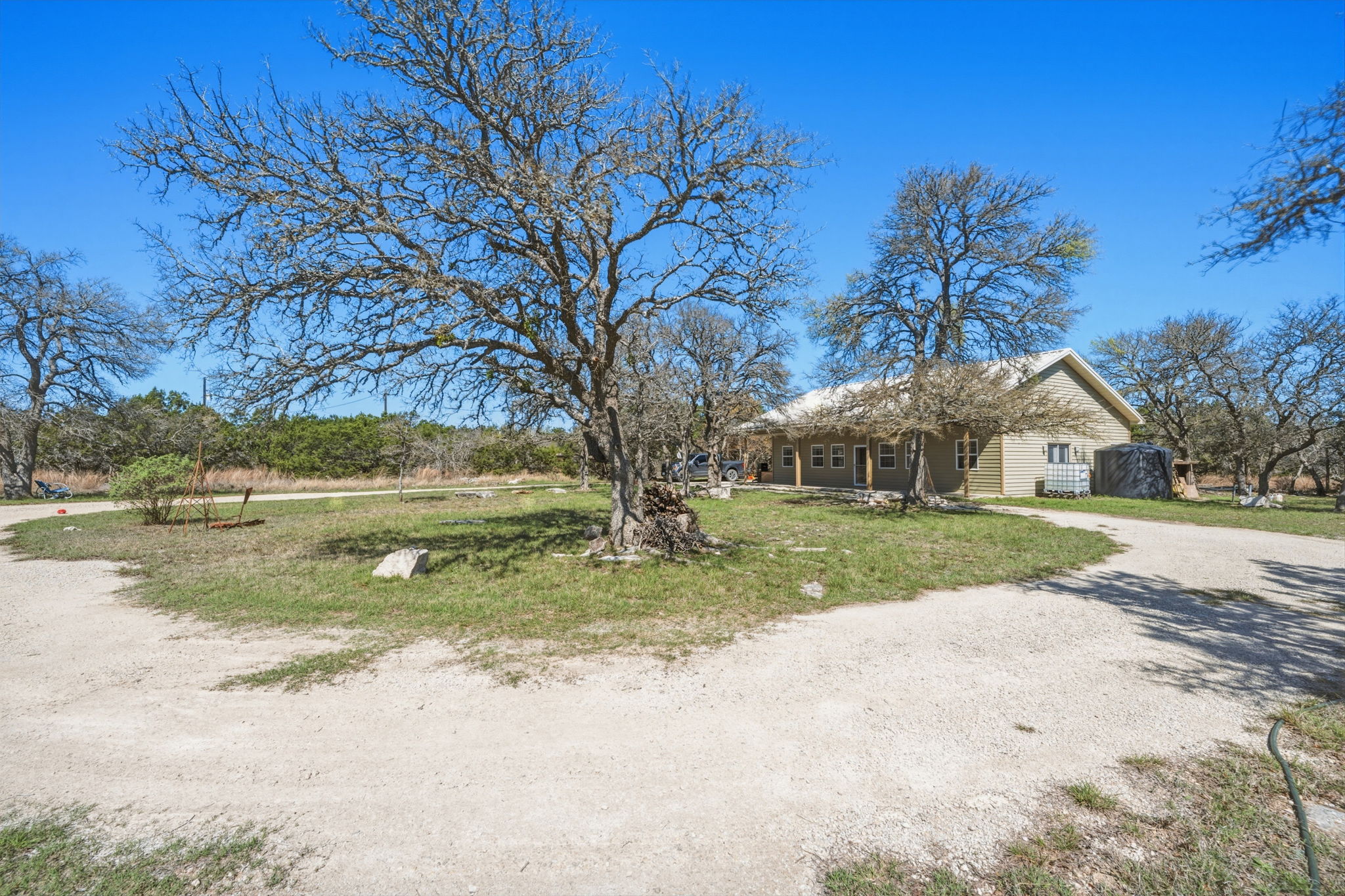 1301 Altwein Road Blanco, TX 78606 - Photo 8 of 40 View of front facade featuring a porch, driveway, and a front lawn