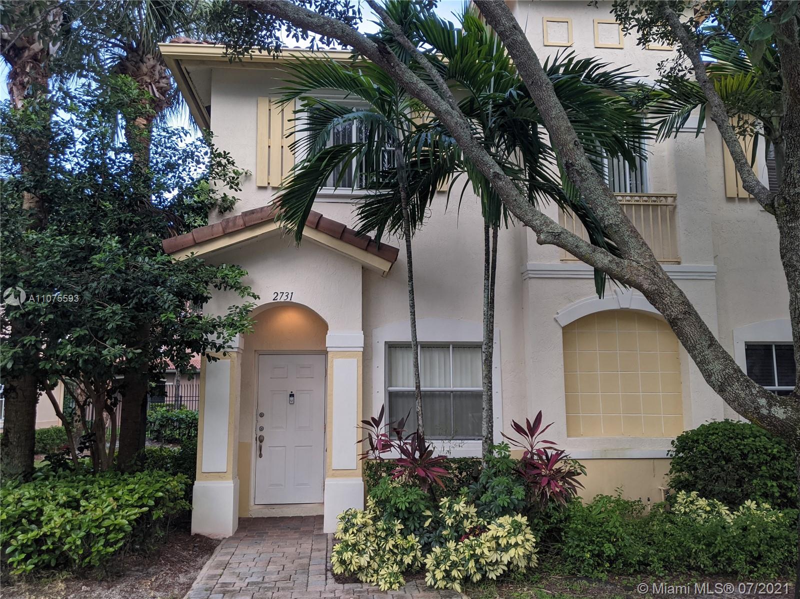 2731 Southwest 83rd Terrace, Unit 101 Miramar, FL 33025 - Photo 1 of 28 a front view of a house with a garden