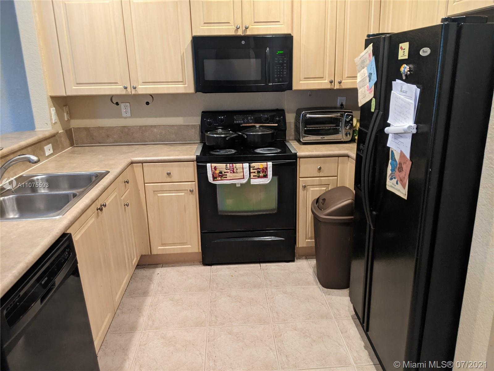2731 Southwest 83rd Terrace, Unit 101 Miramar, FL 33025 - Photo 11 of 28 a kitchen with stainless steel appliances granite countertop a refrigerator stove and sink