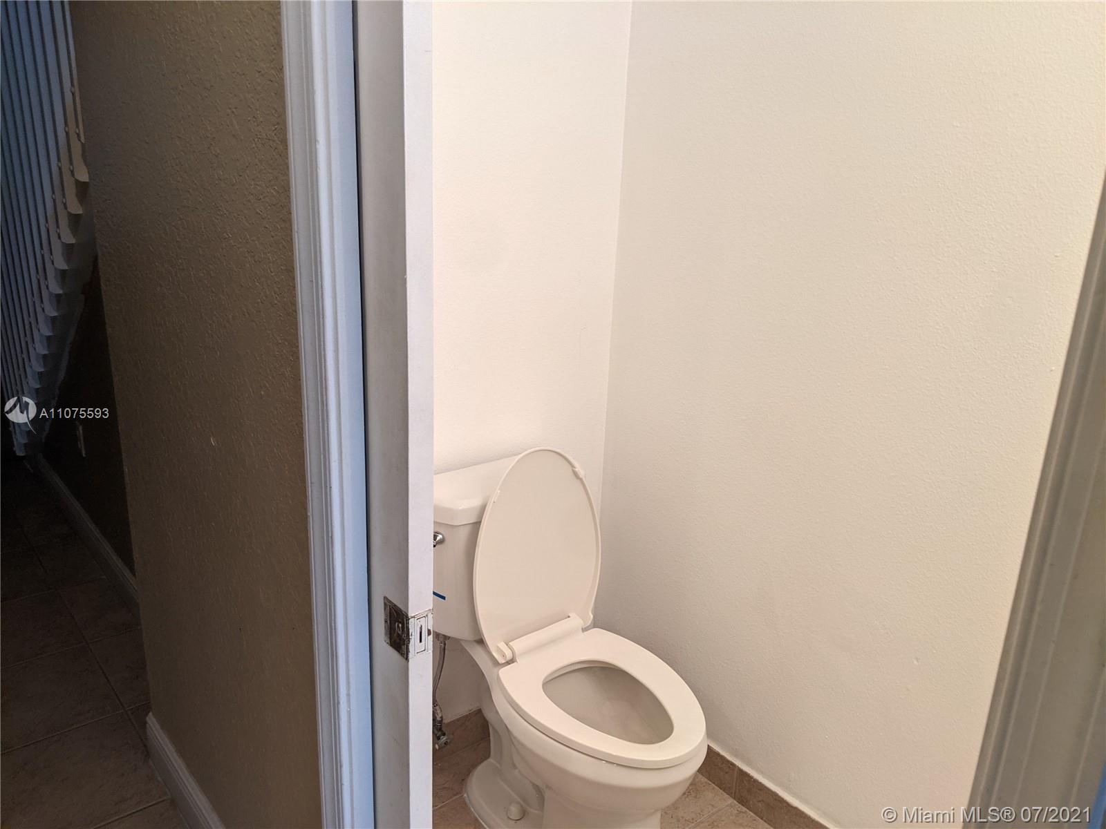 2731 Southwest 83rd Terrace, Unit 101 Miramar, FL 33025 - Photo 17 of 28 a white toilet sitting next to a shower