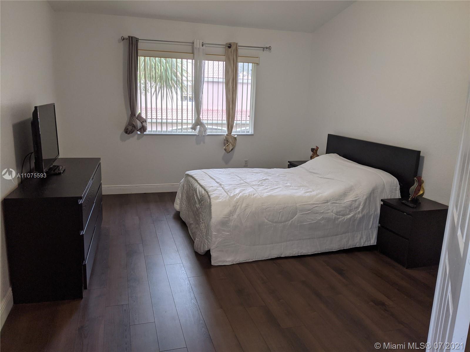 2731 Southwest 83rd Terrace, Unit 101 Miramar, FL 33025 - Photo 19 of 28 a bedroom with a bed and wooden floor
