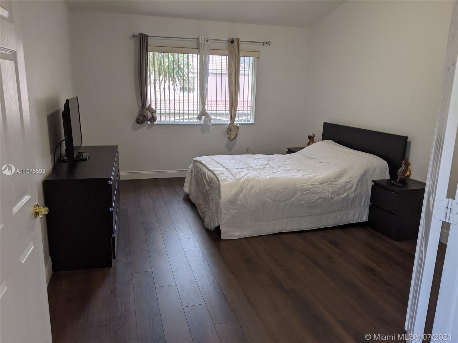 2731 Southwest 83rd Terrace, Unit 101 Miramar, FL 33025 - Photo 20 of 28 a bedroom with a bed and wooden floor