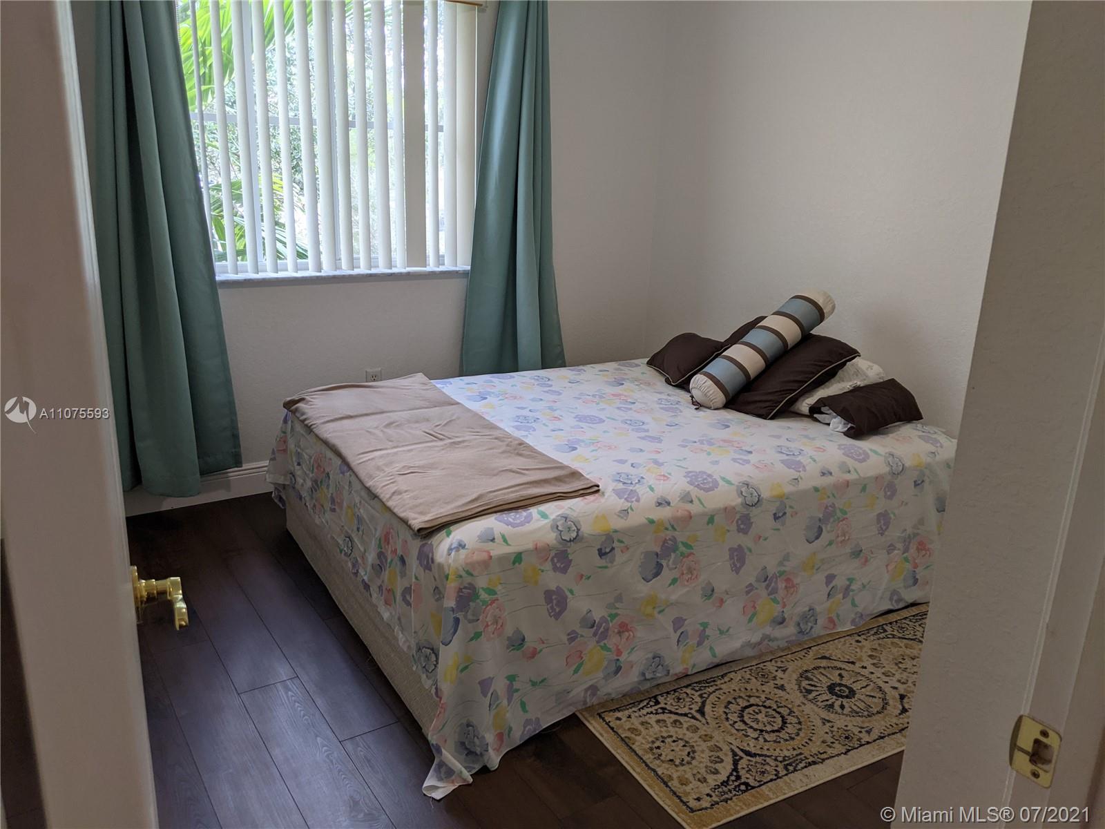 2731 Southwest 83rd Terrace, Unit 101 Miramar, FL 33025 - Photo 23 of 28 a bed sitting in a bedroom next to a window