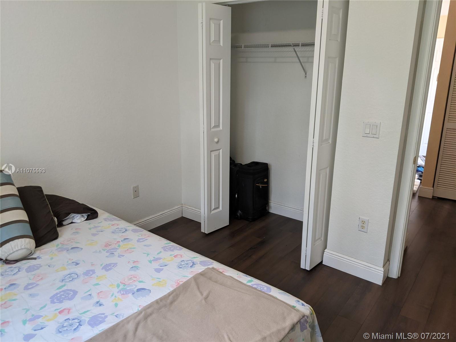 2731 Southwest 83rd Terrace, Unit 101 Miramar, FL 33025 - Photo 24 of 28 a bedroom with a bed and wooden floor