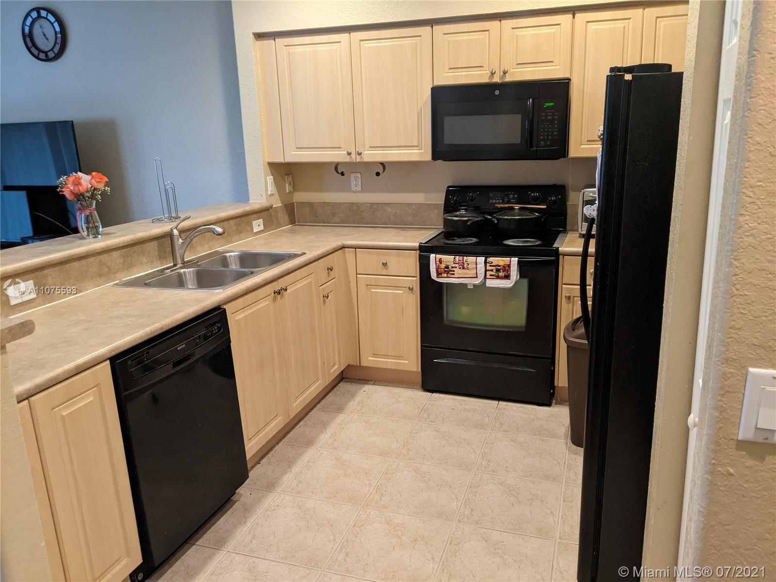 2731 Southwest 83rd Terrace, Unit 101 Miramar, FL 33025 - Photo 10 of 28 a kitchen with a sink stove and refrigerator