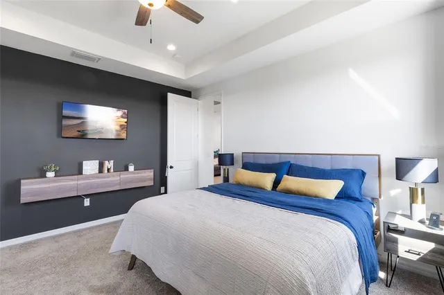 a bedroom with a large bed and a chandelier