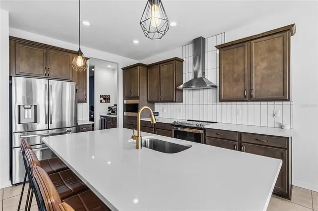 a kitchen with stainless steel appliances granite countertop a sink and a refrigerator