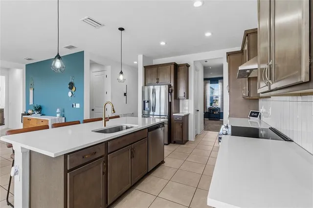 a kitchen with stainless steel appliances granite countertop a sink a counter and chairs