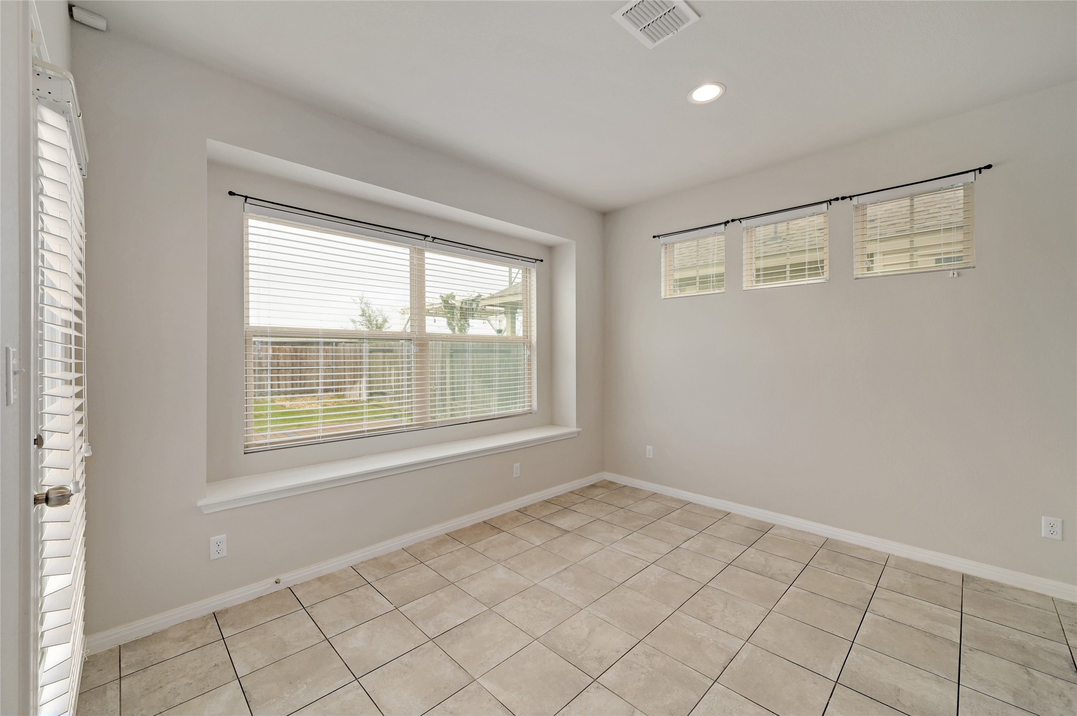 702 Nautical Loop Kyle, TX 78640 - Photo 16 of 27 This room features a window seat, tiled flooring, and multiple windows, including a large window with blinds and three smaller windows providing natural light