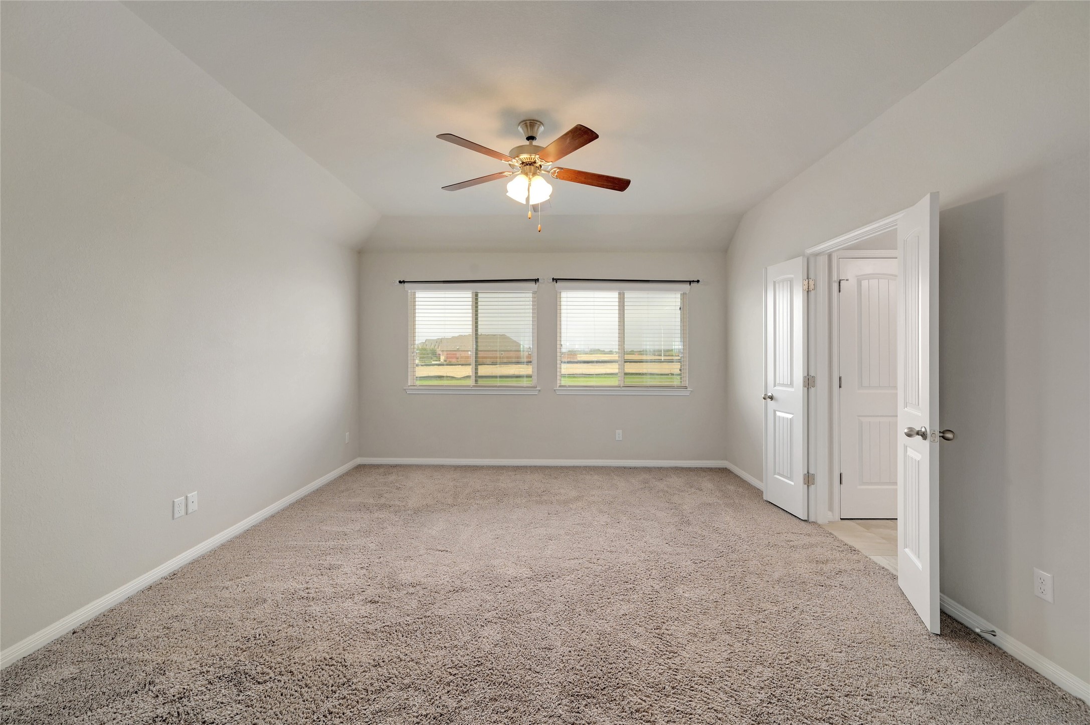 702 Nautical Loop Kyle, TX 78640 - Photo 17 of 27 This expansive room features neutral-toned carpet, light gray walls, and two windows providing exterior views