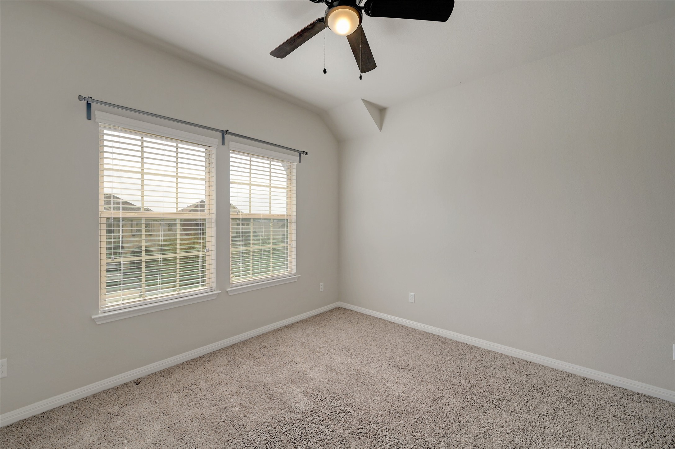 702 Nautical Loop Kyle, TX 78640 - Photo 22 of 27 This room features two windows with blinds, a ceiling fan with lighting, and carpeted flooring