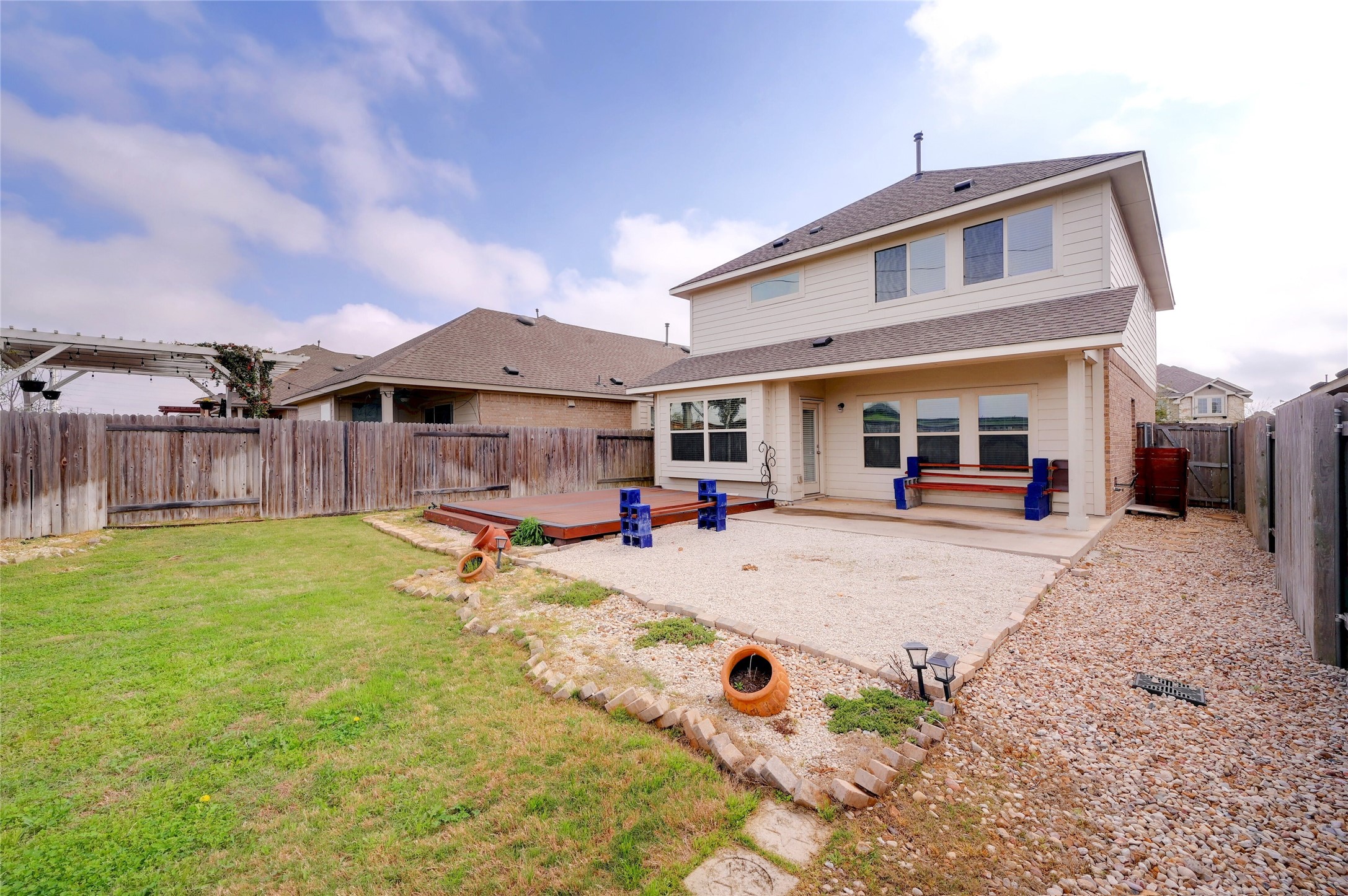 702 Nautical Loop Kyle, TX 78640 - Photo 24 of 27 The property includes a spacious backyard featuring a well-maintained lawn, a wooden fence, a gravel area, and a paved patio