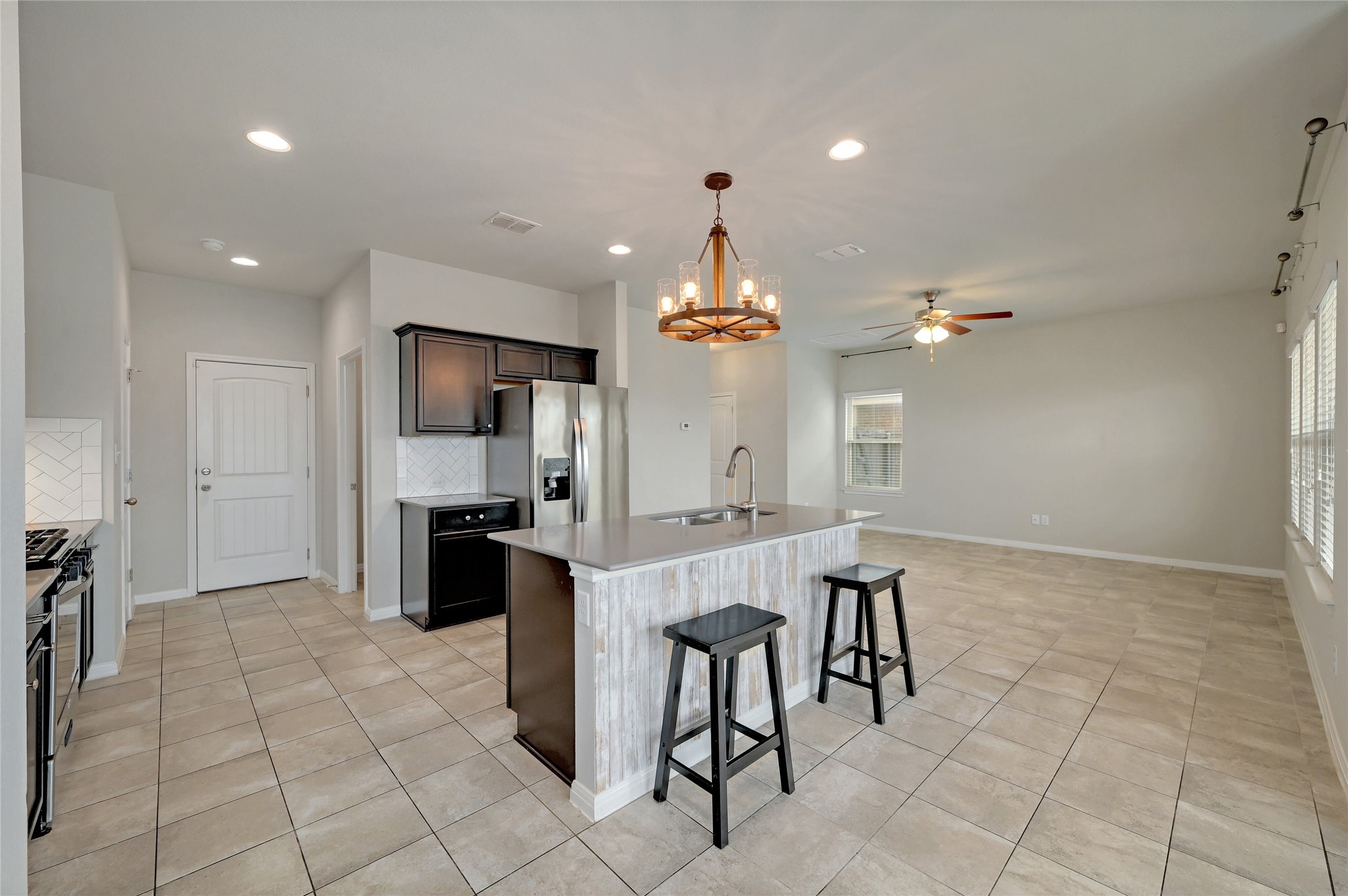 702 Nautical Loop Kyle, TX 78640 - Photo 10 of 27 The spacious kitchen features tile flooring, dark wood cabinetry, and stainless steel appliances