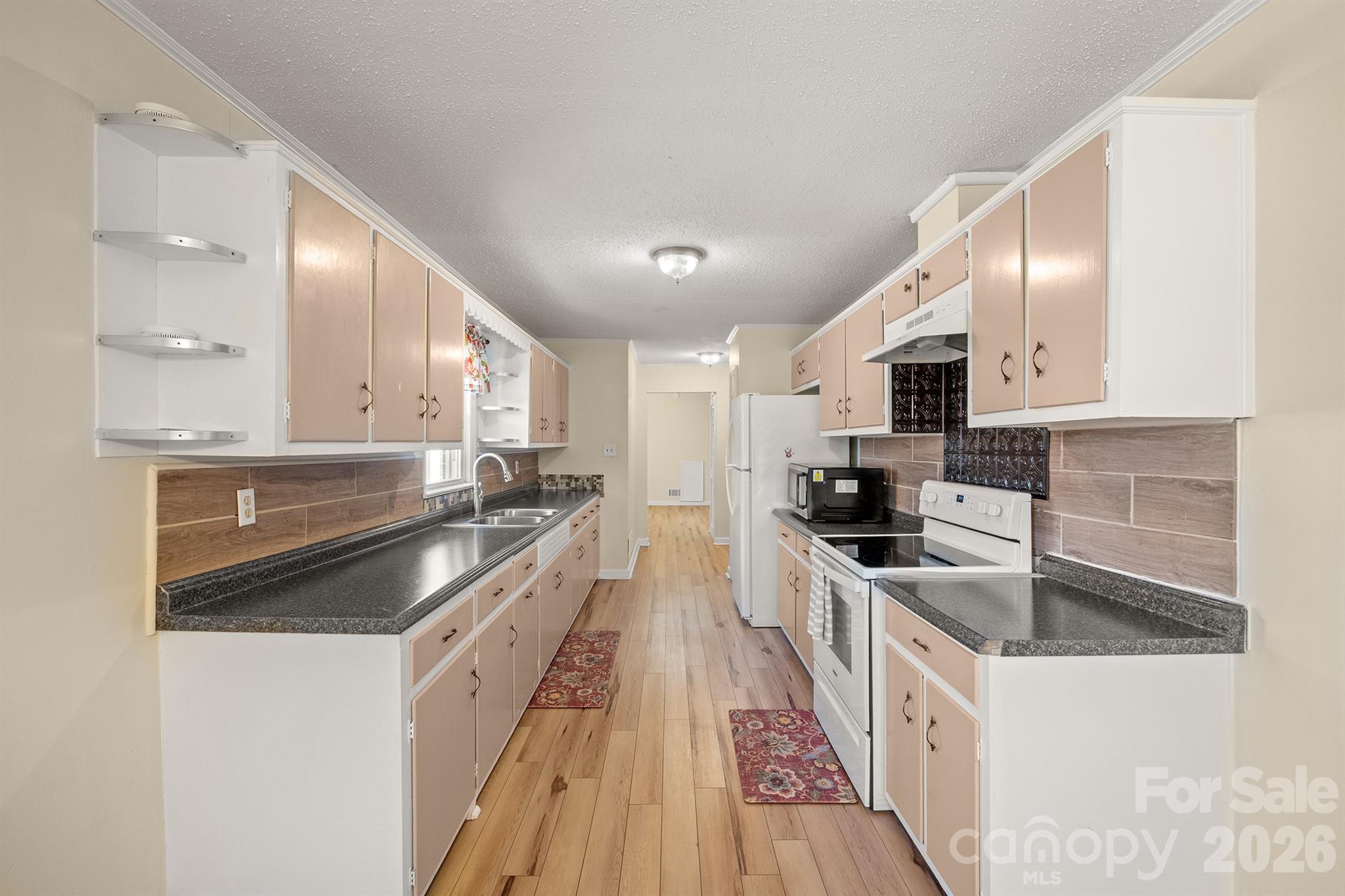 6264 Highway 221 Marion, NC 28752 - Photo 23 of 41 a kitchen with stainless steel appliances a sink a stove top oven a sink a chimney and cabinets