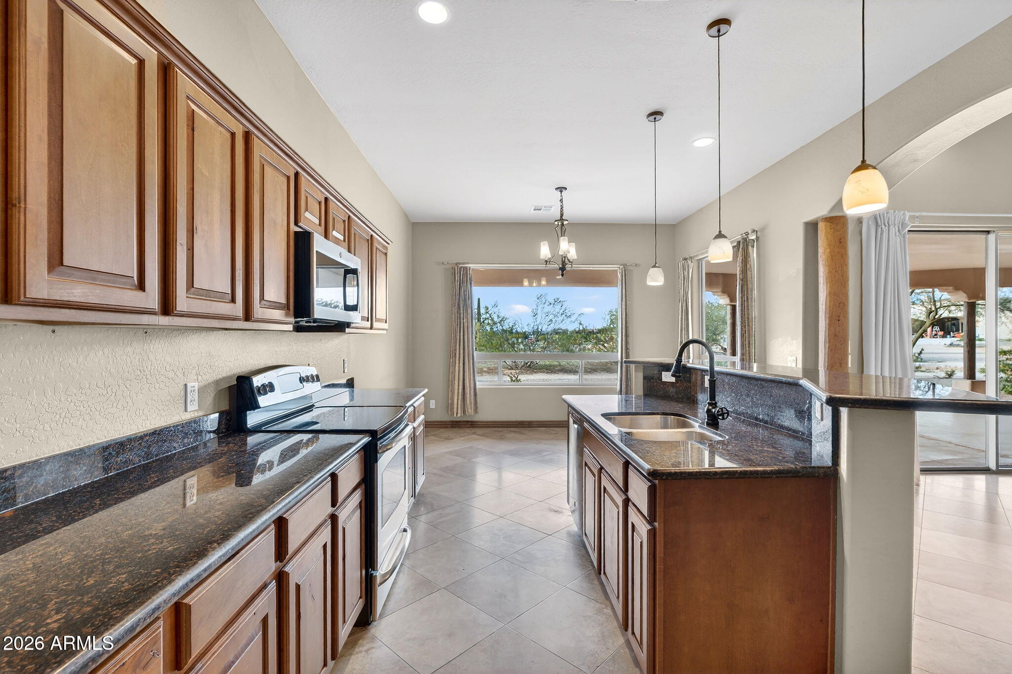 10000 Ginger Way Casa Grande, AZ 85194 - Photo 28 of 93 a kitchen with stainless steel appliances granite countertop a sink a stove and a wooden cabinets
