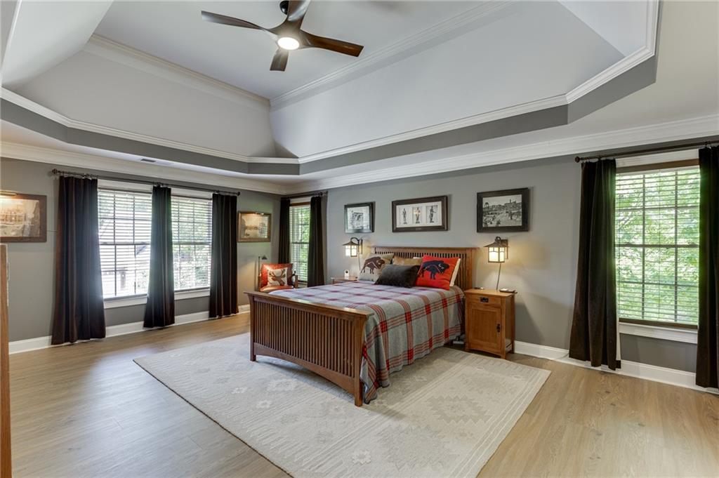 2758 Pathview Drive Dacula, GA 30019 - Photo 4 of 48 a spacious bedroom with a large bed and a chandelier fan