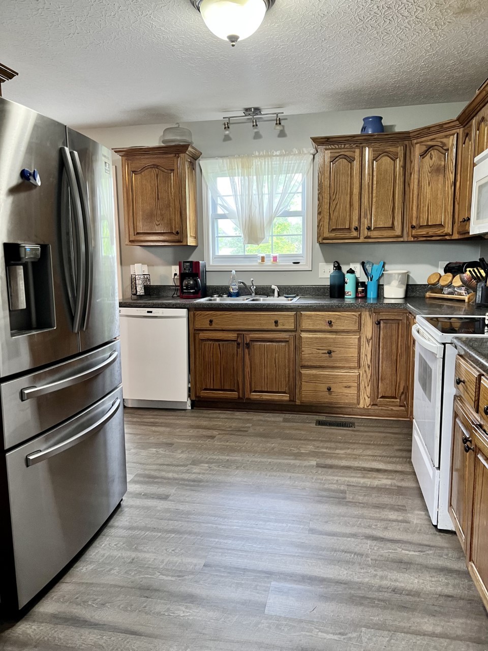 1004 Roland Court Cottontown, TN 37048 - Photo 5 of 22 a kitchen with granite countertop a refrigerator stove and sink