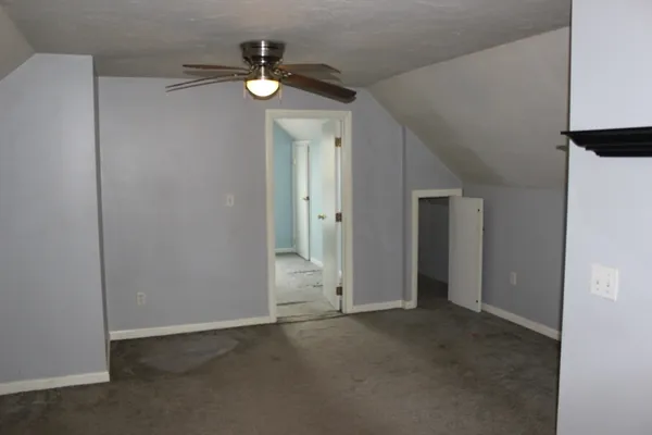 a view of an empty room with a ceiling fan