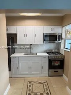 a kitchen with stainless steel appliances granite countertop a stove and a microwave