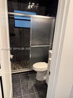 a bathroom with a toilet and a shower