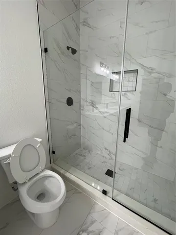 a bathroom with a shower a toilet and a sink