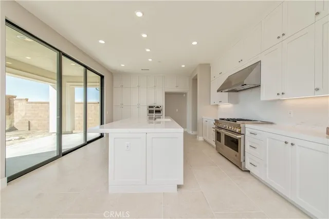 a kitchen with stove and white cabinets