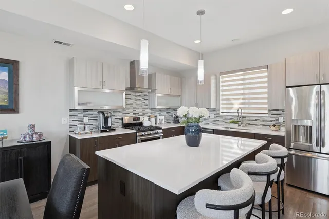 a kitchen with stainless steel appliances a dining table chairs and granite counter tops