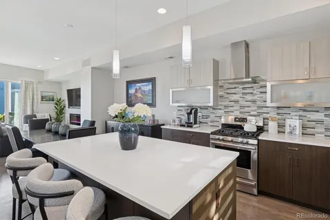 a kitchen with kitchen island a stove a table and chairs in it