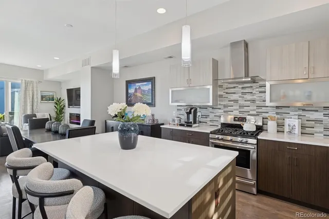 a kitchen with kitchen island a stove a table and chairs in it