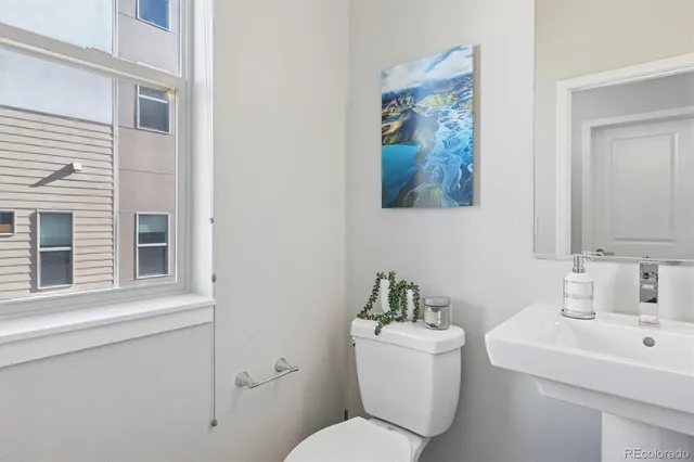 a bathroom with a toilet a sink and a mirror