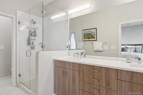 a bathroom with a double vanity sink mirror and shower