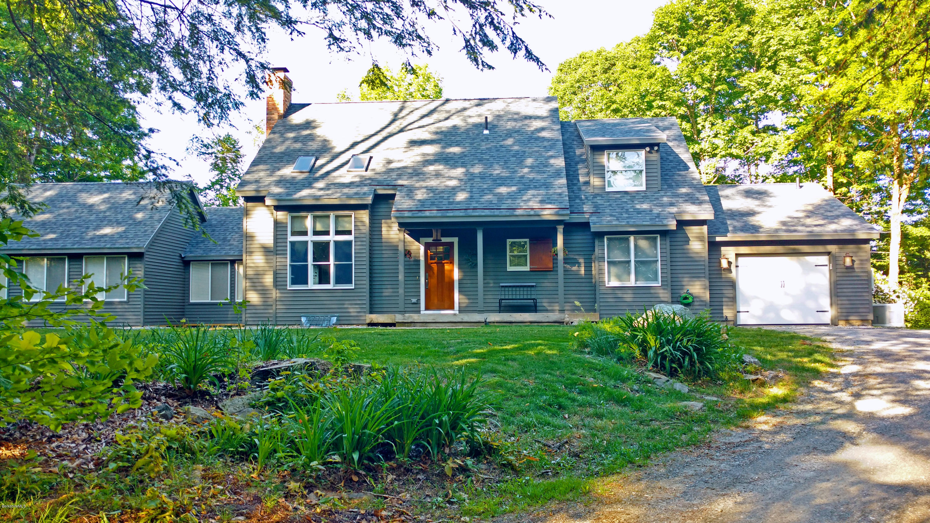 a view of a brick house with a yard and plants
