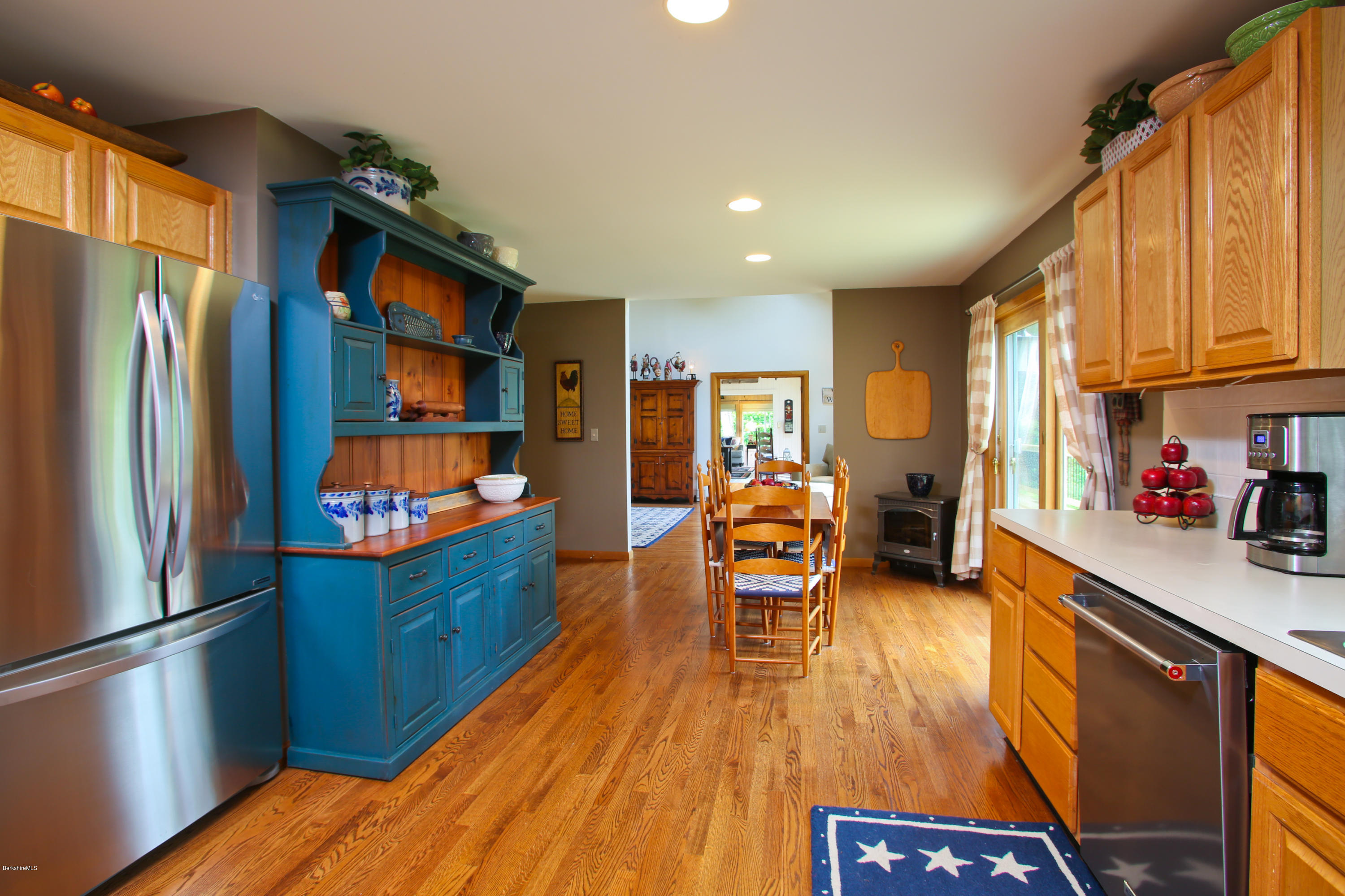 263 Harrington Road Otis, MA 01253 - Photo 12 of 33 a kitchen with stainless steel appliances granite countertop a refrigerator a sink dishwasher a dining table and chairs with wooden floor