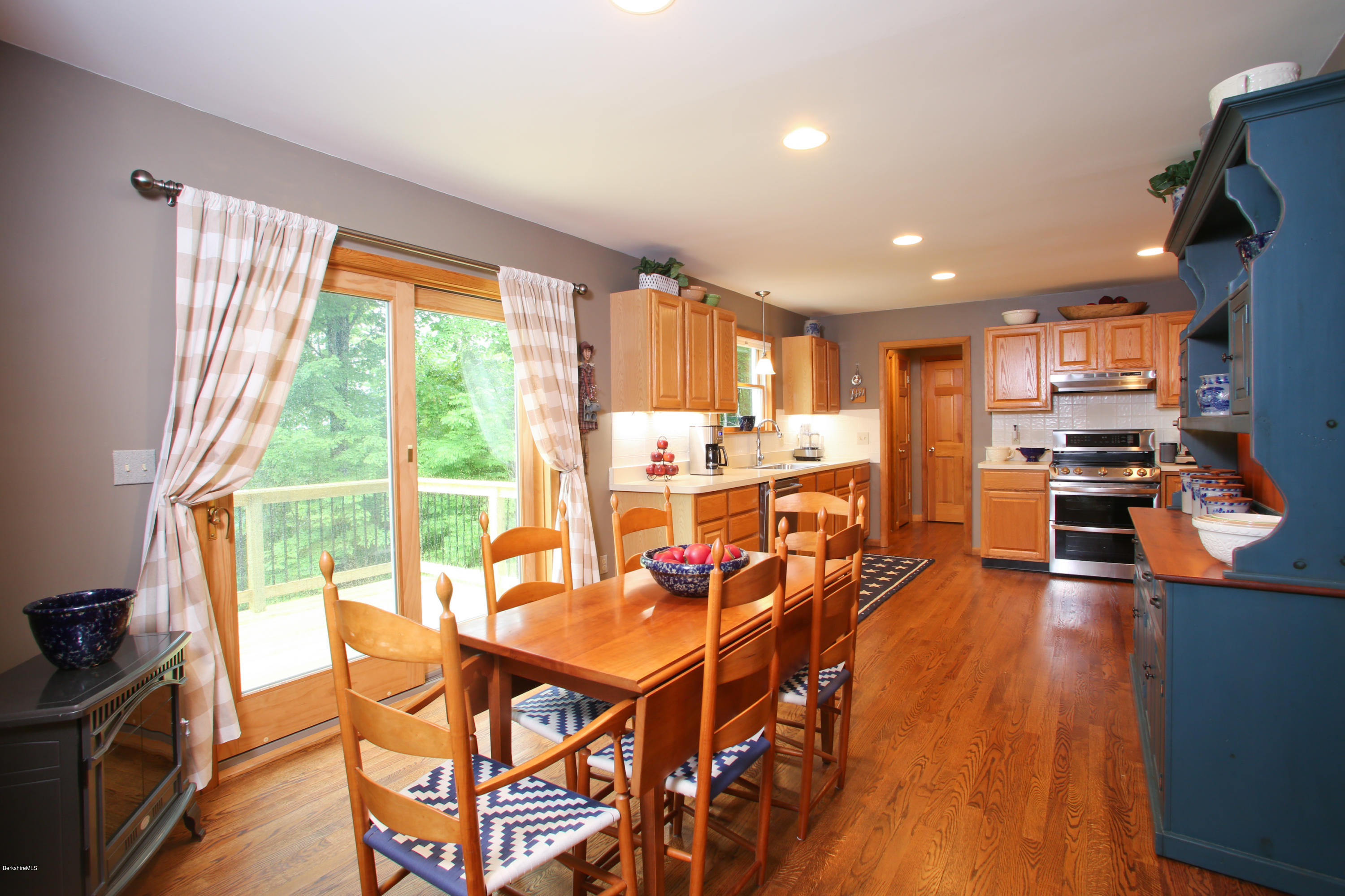 263 Harrington Road Otis, MA 01253 - Photo 13 of 33 a open kitchen with stainless steel appliances granite countertop a stove top oven a dining table and chairs with wooden floor